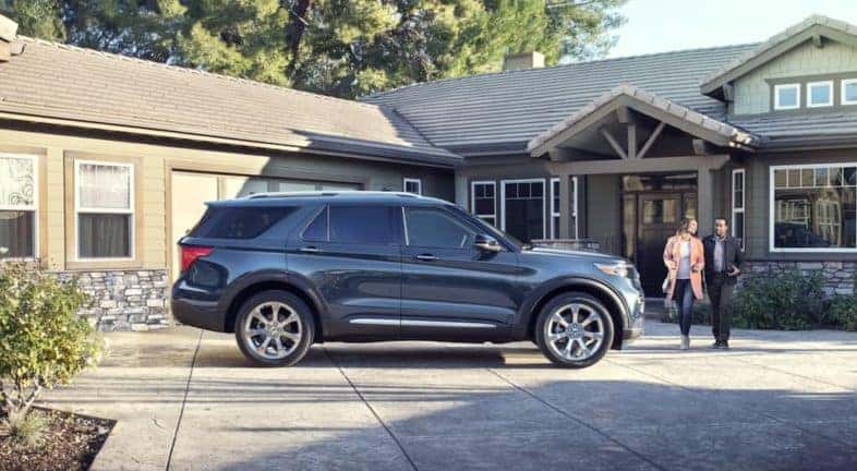 A family is shown walking towards a 2020 pre-owned Ford Explorer.