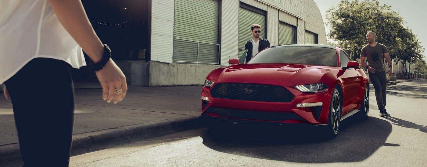 A red 2021 Ford Mustang GT is shown parked in front of a garage.