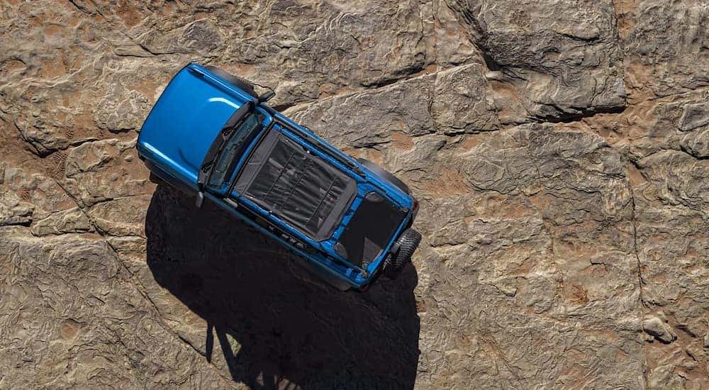 A blue 2022 Ford Bronco Black Diamond is shown from a high angle parked on stone.