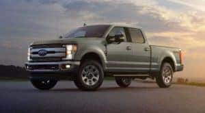 A green 2019 Ford Super Duty is shown from the side parked at sunset.