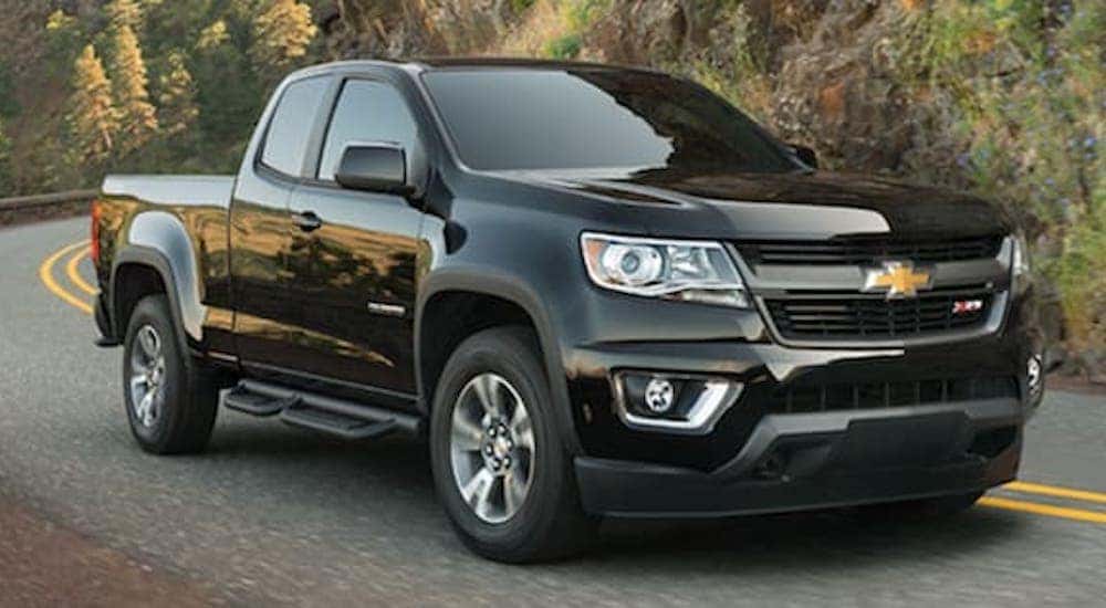 A black 2019 Chevy Colorado is shown parked on a two lane road.