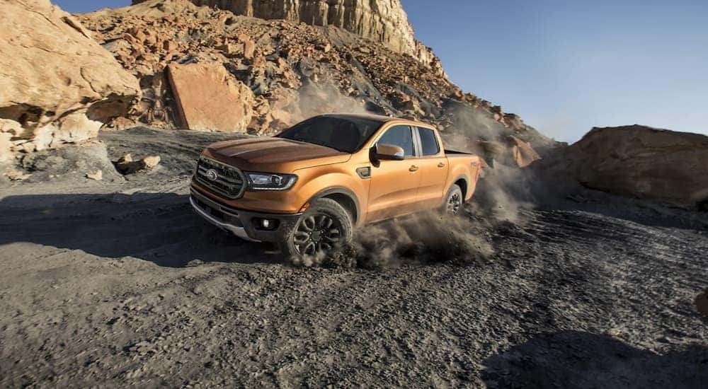 A gold 2020 Ford Ranger is shown from the front at an angle while driving off road.