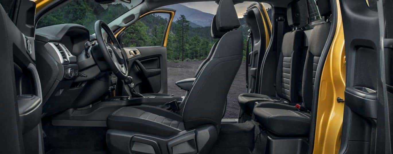 The interior of a yellow 2022 Ford Ranger XLT SuperCab is shown with doors open.