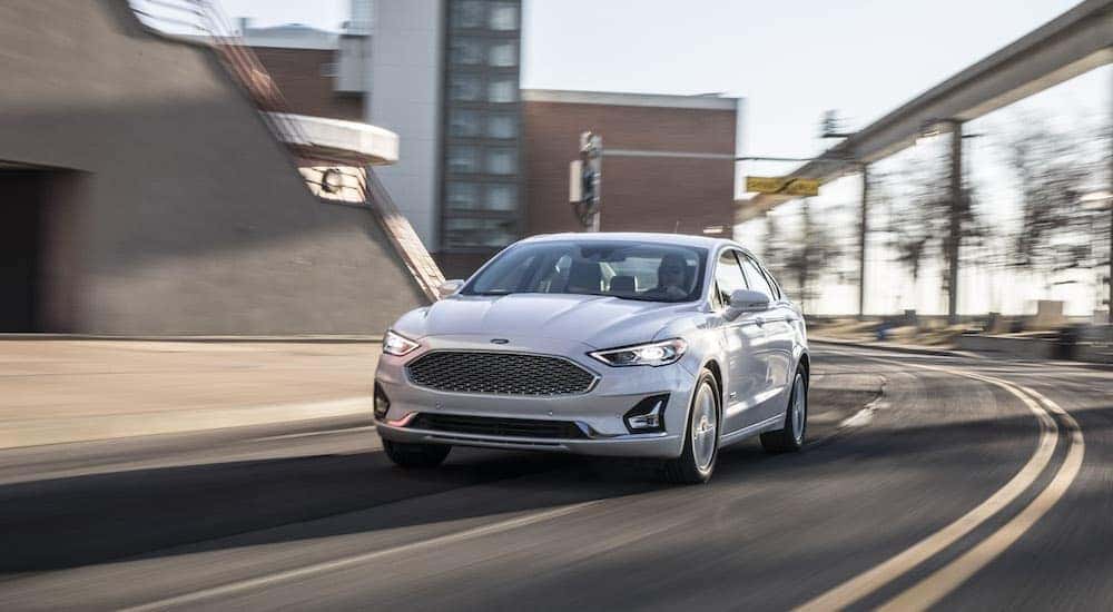 A white 2020 Ford Fusion is shown from the front while it rounds a corner.