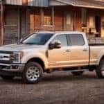 A white 2017 ford F-350 Super Duty is shown from the side in front of a barn.