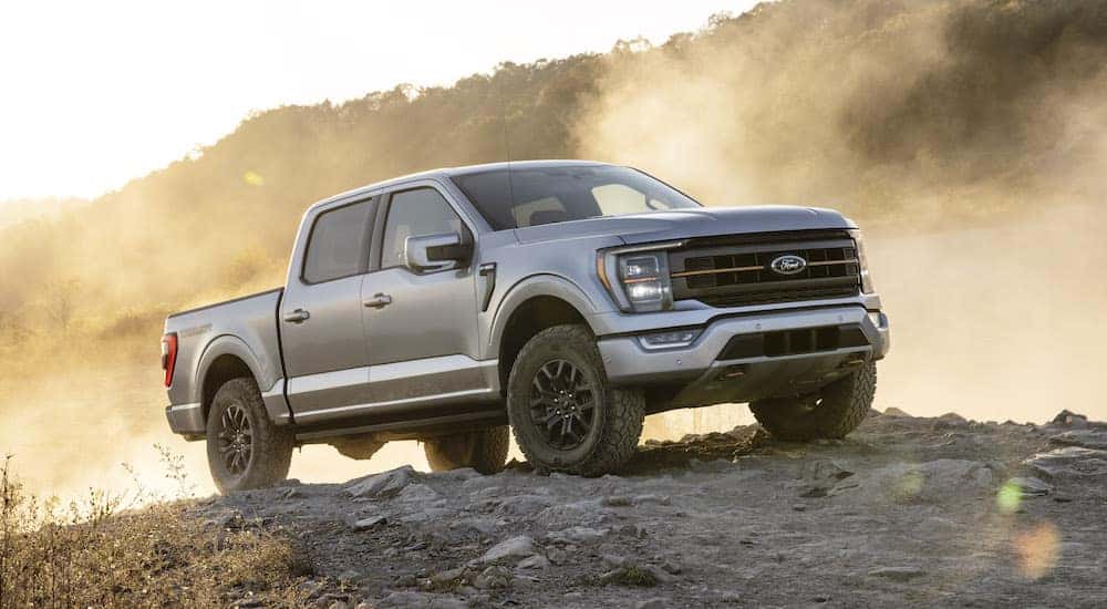 A silver 2021 Ford F-150 Tremor is shown from the front at an angle while parked off-road after the owner searched 'Used car dealers Upstate NY'.