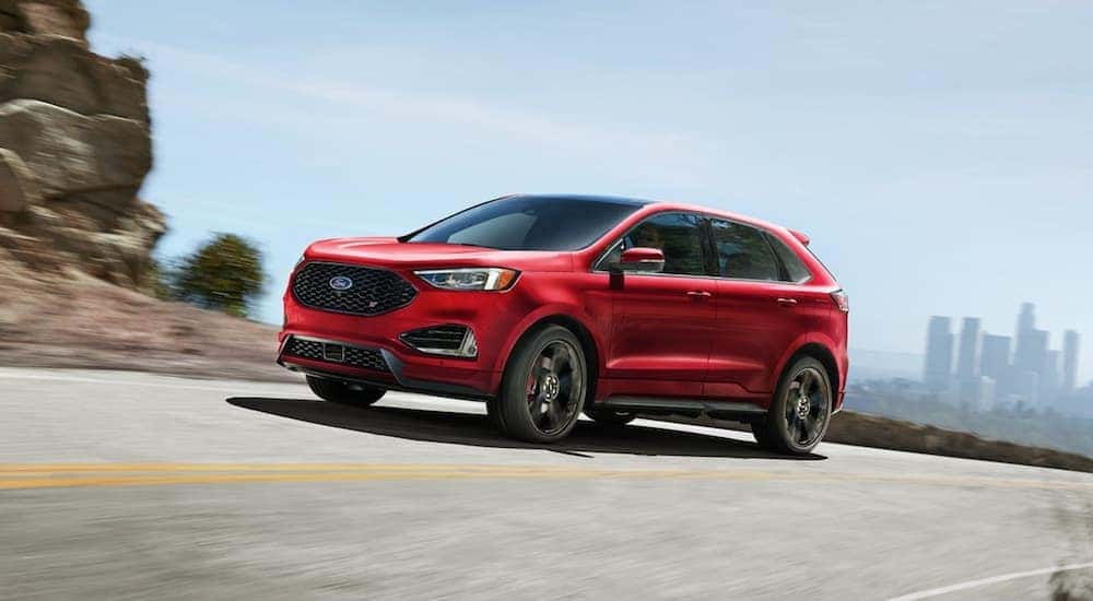 A red 2020 Ford Edge ST driving from used car dealerships in Albany NY.