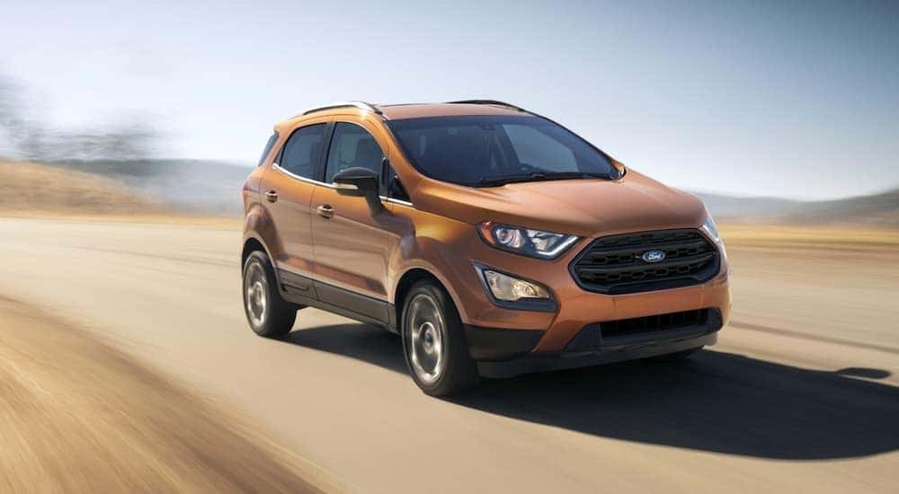 A yellow 2021 Ford EcoSport is shown from the front at an angle after leaving a Latham used Ford dealer