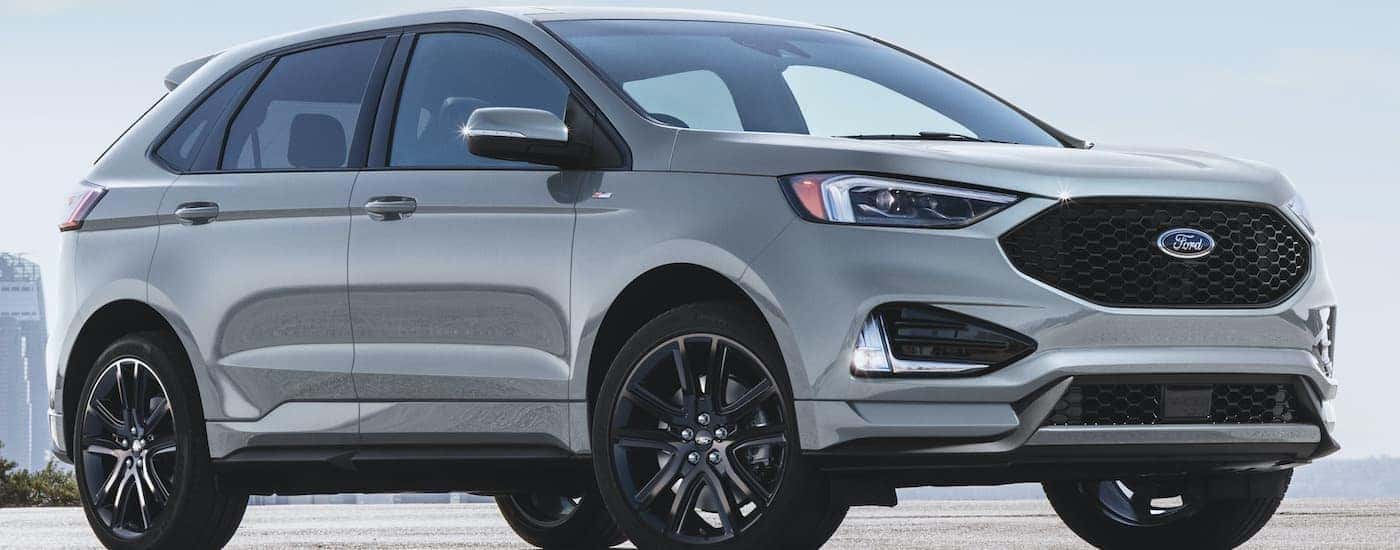 A silver 2020 Ford Edge is shown from the side parked under a blue sky.