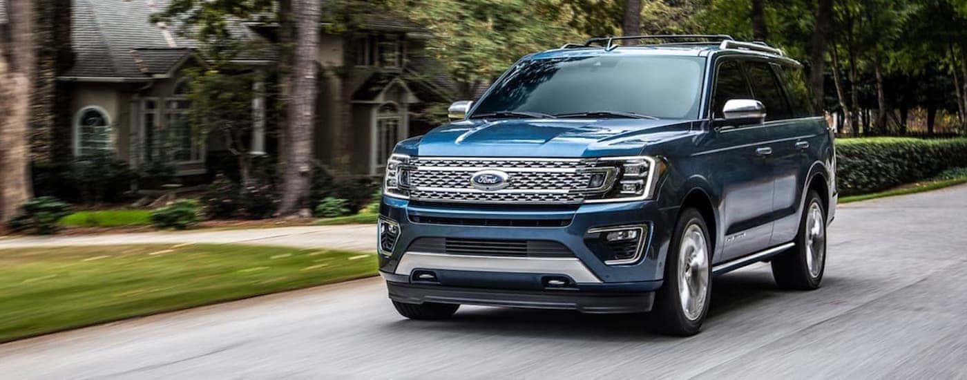A blue 2020 Ford Expedition is shown from the front driving on an open road.