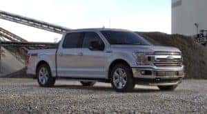 A popular certified Ford for sale, a silver 2020 Ford F-150 is shown from the side parked on a construction site.