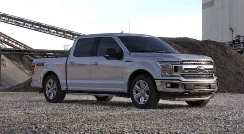 A popular certified Ford for sale, a silver 2020 Ford F-150 is shown from the side parked on a construction site.