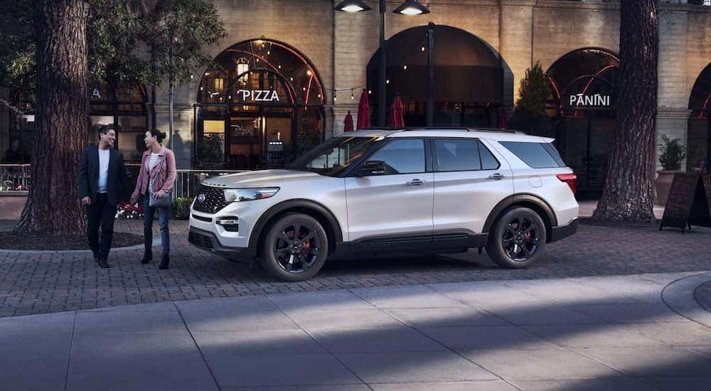 A white 2022 Ford Explorer ST is shown parked in front of a restaurant.