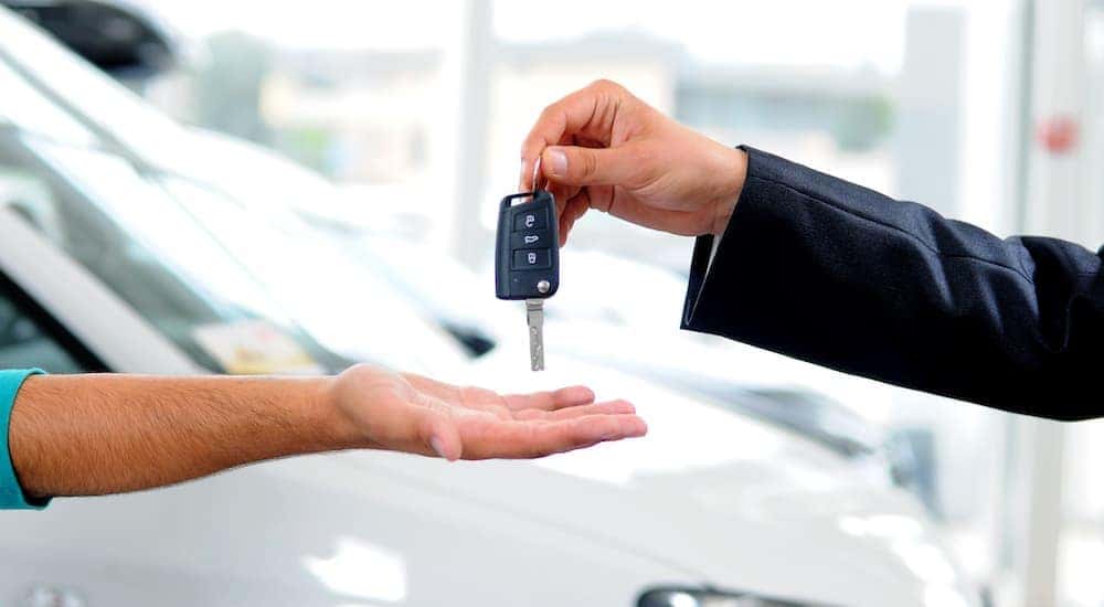 Someone is shown handing over their keys after they decided 'I need to sell my car'.