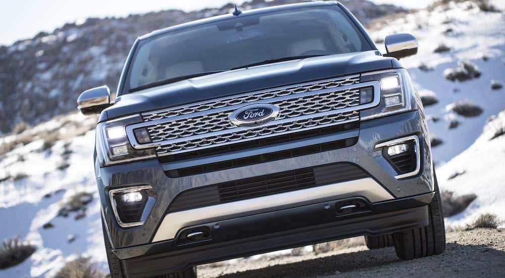 A grey 2018 Ford Expedition is shown parked off-road on a snowy path.