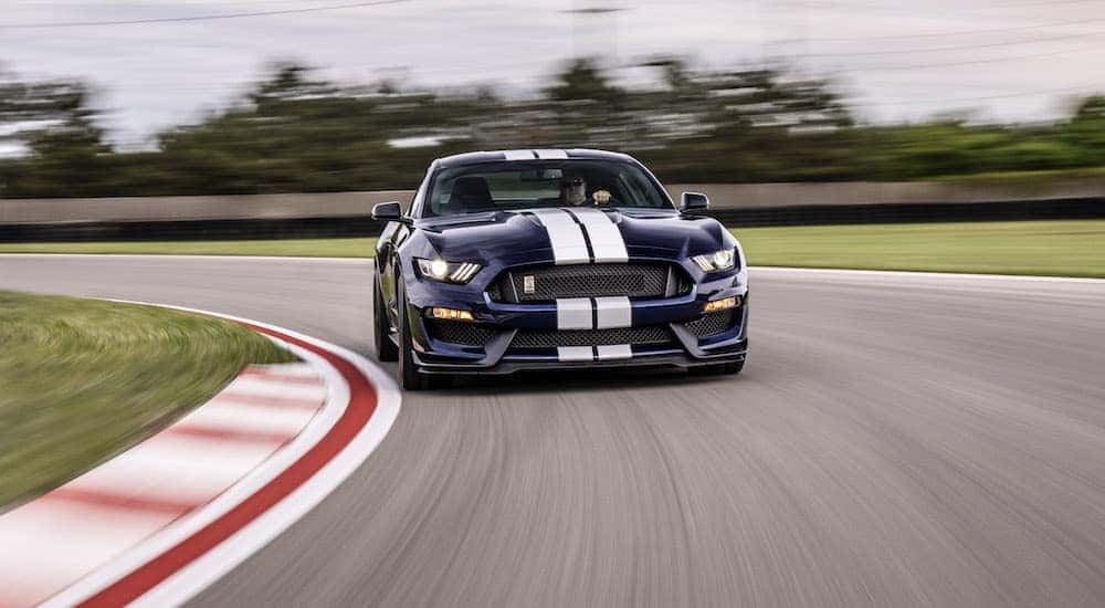 A popular Certified Pre-Owned Ford, a dark blue 2019 Ford Mustang GT350, is shown on a race track.