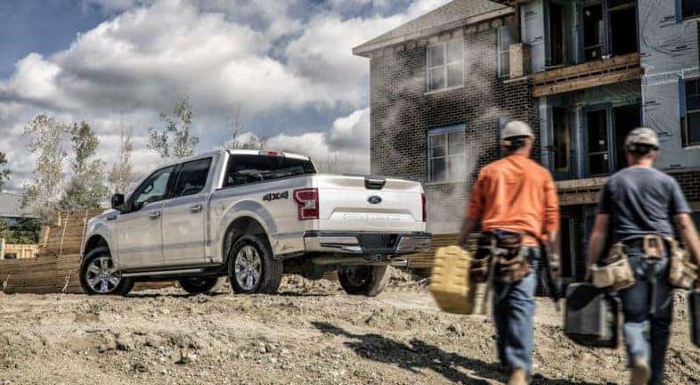 A silver 2020 Ford F-150 is shown from behind on a construction site.