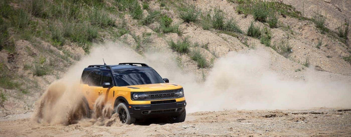 A yellow 2021 Ford Bronco Sport is shown off-roading.