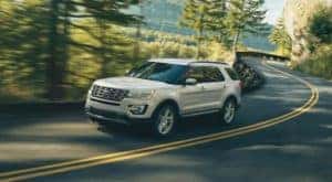 A popular used Ford Explorer of sale, a white 2017 Ford Explorer is shown driving on an open road.