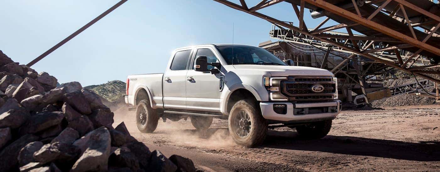 A white 2021 Ford F-250 Super Duty is shown from the front at an angle on a jobsite.