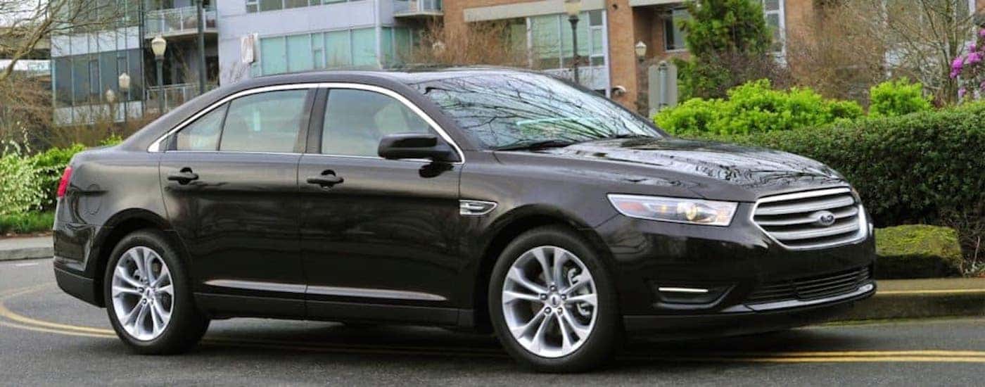 A black 2012 Ford Taurus is shown from the side.