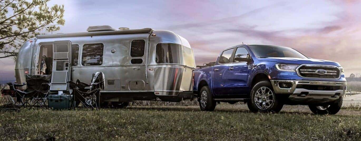 A blue 2023 Ford Ranger is shown towing a trailer during a 2023 Ford Ranger vs 2023 Chevy Colorado comparison.