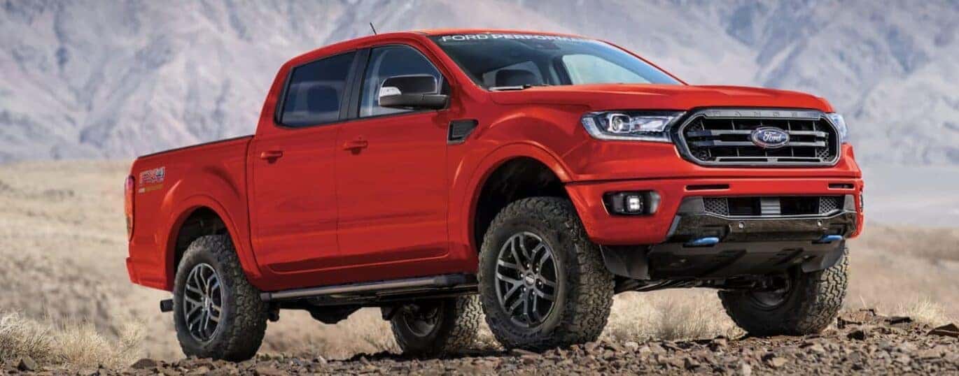 A red 2023 Ford Ranger is shown from the side parked in the mountains.