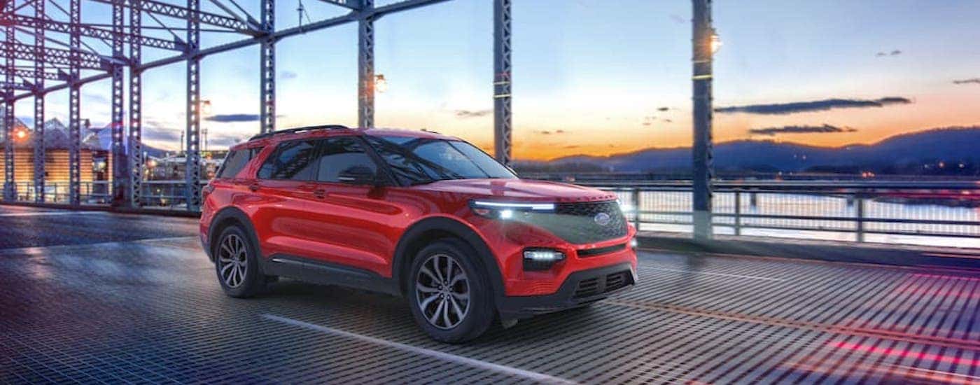 A red 2021 Ford Explorer ST is shown from the side while crossing a bridge.