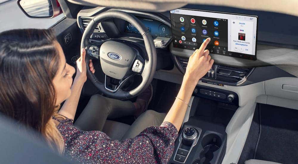 A person is showing selecting an app on the infotainment screen in a 2023 Ford Escape.