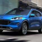 A blue 2020 Ford Escape is shown from the front driving on an open road.