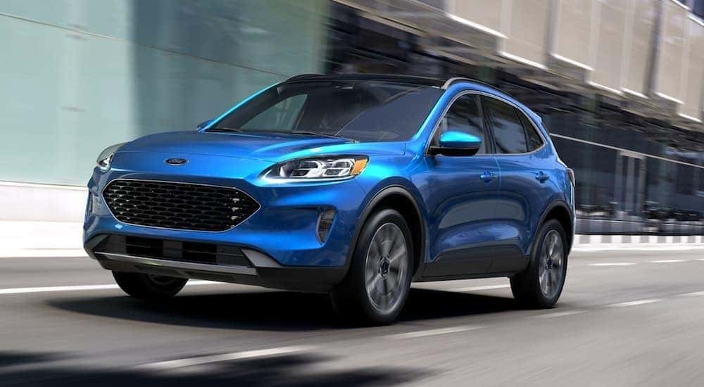 A blue 2020 Ford Escape is shown from the front driving on an open road.