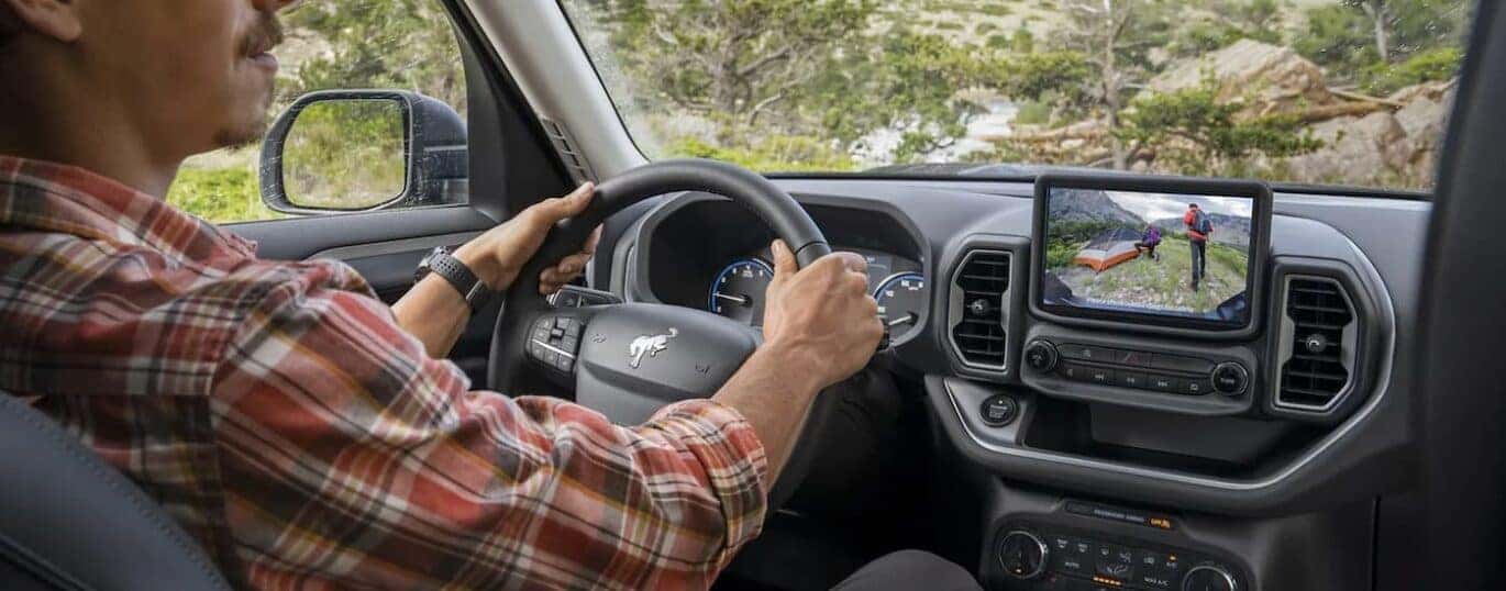A man is shown driving a 2023 Ford Bronco Sport.