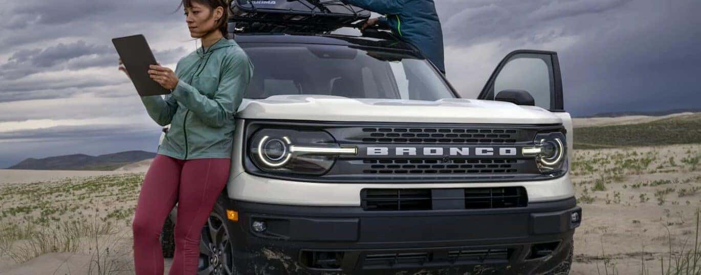 A white 2023 Ford Bronco Sport is shown from the front parked on a beach.