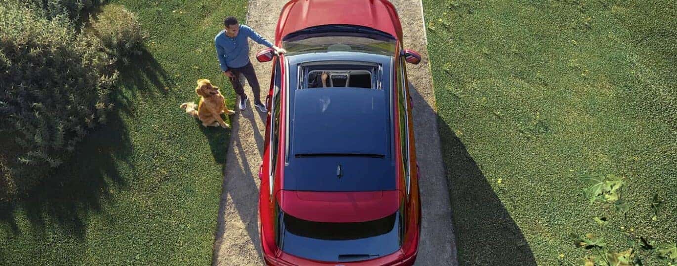 A person is shown standing next to the door of a red 2023 Ford Escape.