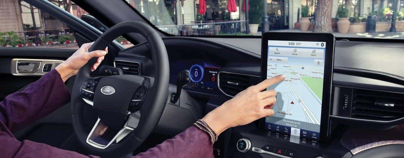 A woman is shown using the touchscreen infotainment screen in a 2023 Ford Explorer.