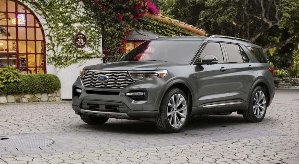 A grey 2023 Ford Explorer Platinum is shown from the side parked on a cobblestone driveway.