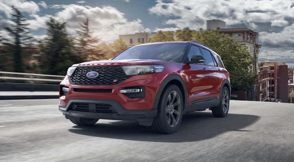 A red 2023 Ford Explorer ST is shown from the front driving on an open road after visiting an Albany Explorer dealer.
