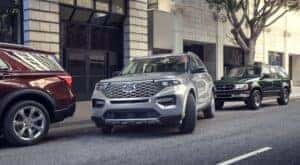 A silver 2023 Ford Explorer is shown leaving a side street parking space.
