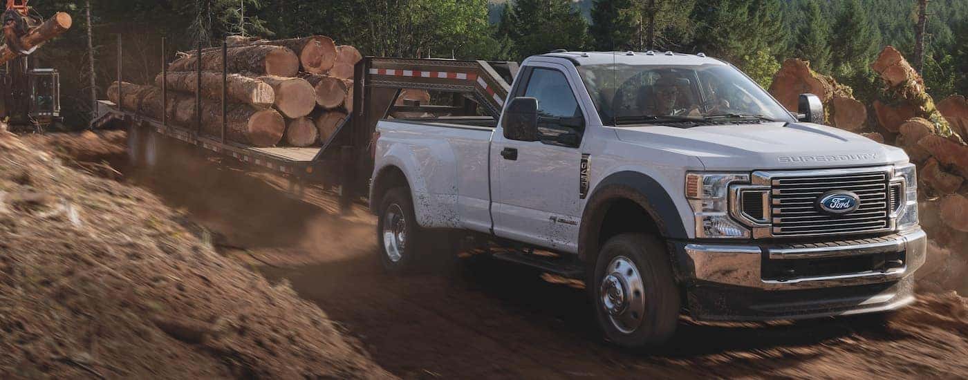 A white 2021 Ford F-350 is shown from the front while towing hay bales.