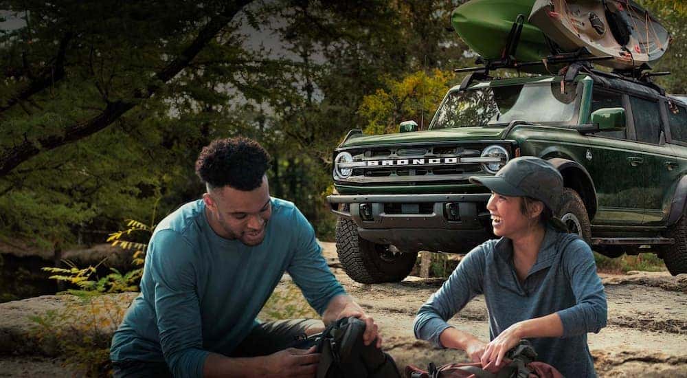 People are shown smiling in front of a green 2023 Ford Bronco after leaving a NY Ford Bronco dealership.
