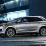 A silver 2023 Ford Edge is shown parked on a city street at night after leaving Ford Edge dealer.