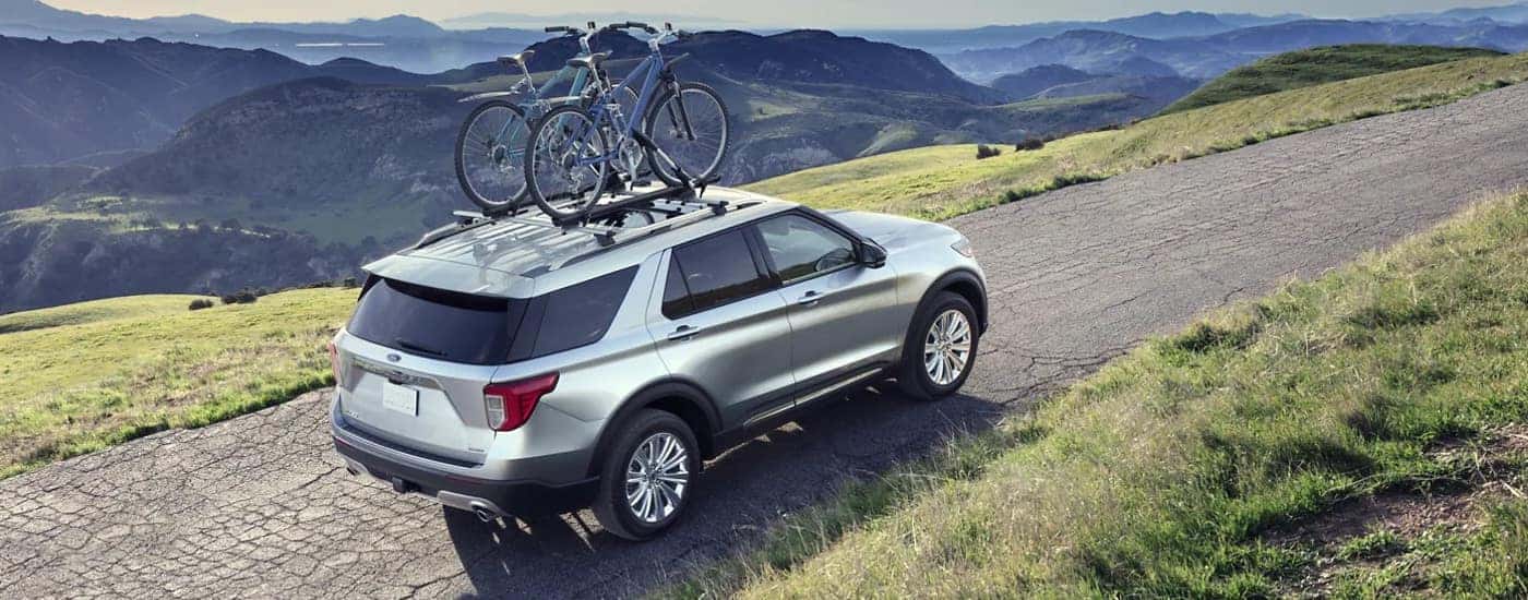 A silver 2022 Ford Explorer is shown driving up a steep road.