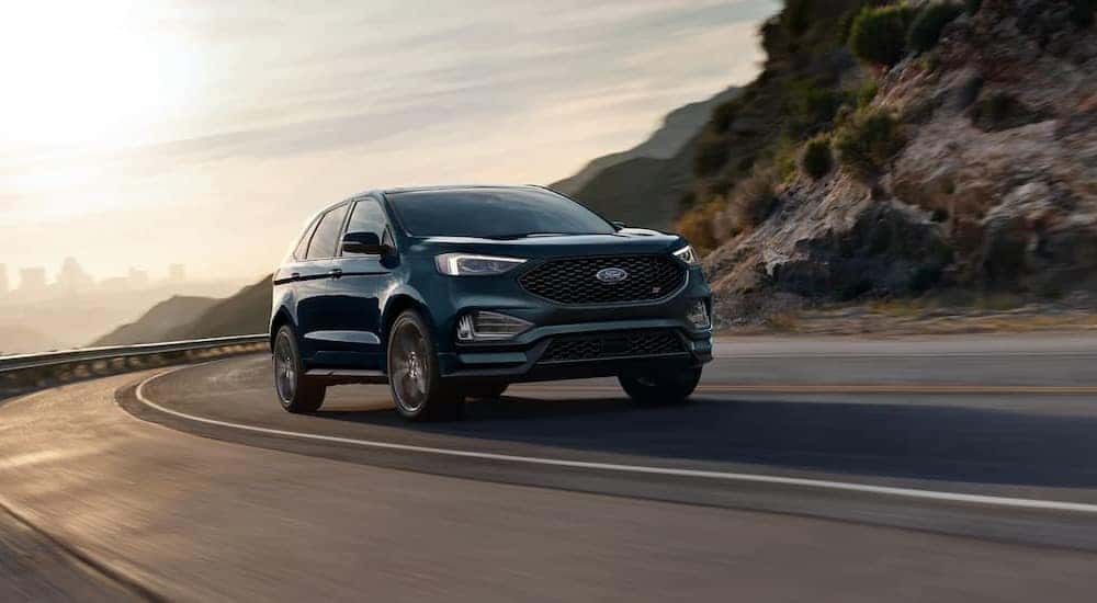 A green 2023 Ford Edge is shown driving on a highway.