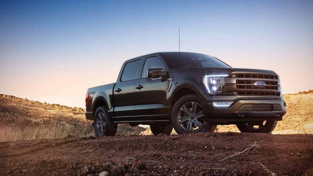 A black 2021 Ford F-150 is shown parked on a dirt hill after visiting a Saratoga, NY used Ford dealer.