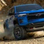 A blue 2023 Chevy Colorado ZR2 is shown off-roading after visiting Saratoga, NY used truck sales.