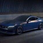 A blue 2024 Ford Mustang Dark Horse is shown from the front at an angle.