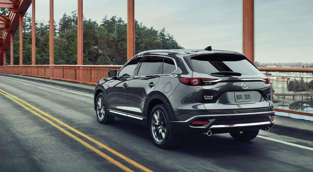A silver 2020 Mazda CX-9 is shown driving on a bridge.