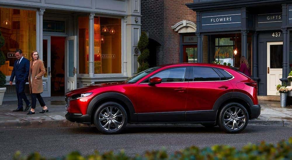 A red 2023 Mazda CX-30 is shown parked near a flower shop.