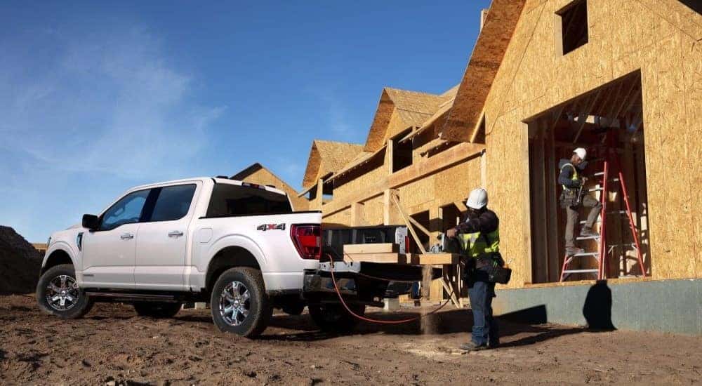 A white 2022 Ford F-150 is shown on a construction site.