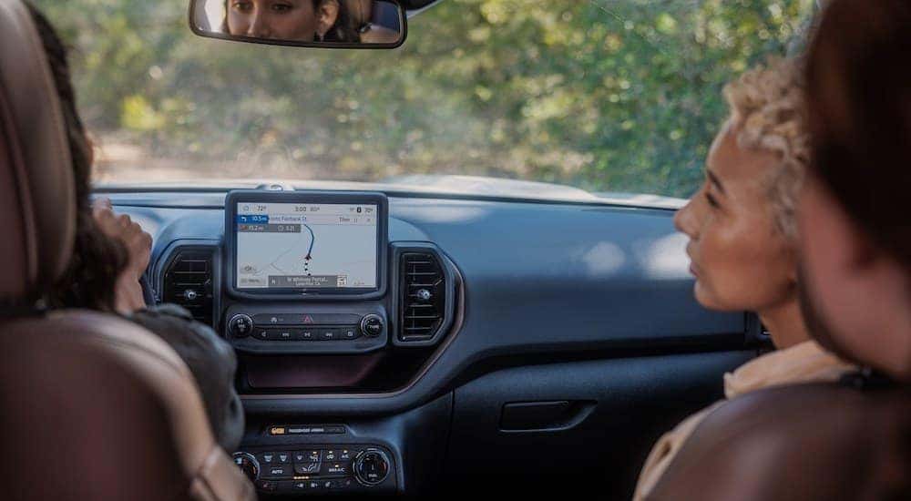 Two people are shown conversing in the black interior of a 2024 Ford Bronco Sport Badlands.